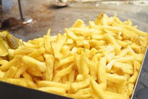 A Pile of Golden Crispy French Fries Located in a Bustling Fast Food Setting Enjoying Popularity photo