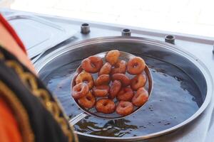 Freshly fried donuts are being prepared in hot oil, creating a delightful aroma in the air photo