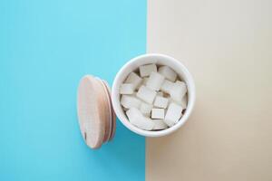 Sugar cubes artfully arranged in a white container with a vibrant, colorful background photo