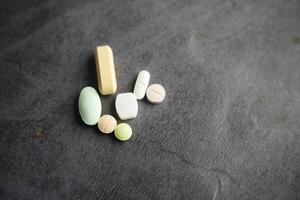 A variety of Assorted Pills and Tablets beautifully displayed on a Dark Background photo