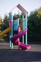 A Colorful Playground Slide and Structure Set Against a Beautiful Sunny Park Scene photo