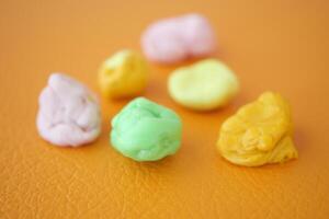 Closeup of colorful Bubble Gum on a orange color background . photo