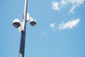 A modern surveillance camera is positioned on a clear day, capturing the surrounding environment photo