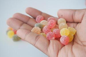 A Vibrant and Colorful Assortment of Delicious Fruit Flavored Gummies Held in a Hand photo