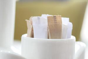 white sugar in a paper packet on table photo