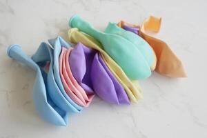 A Bright and Colorful Assortment of Party Balloons Spread Out on a Marble Surface photo