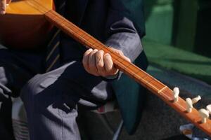 A Skilled Musician Enthusiastically Playing a Traditional Instrument While Dressed in a Suit photo