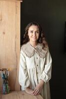 Smiling Artist Standing by Easel in a Bright Studio photo