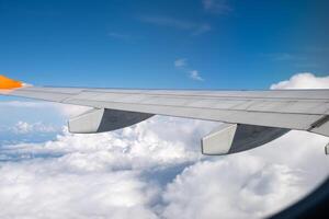 View from airplane window on wing and landscape with clouds on window during flight. photo