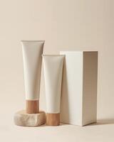 Two white hand cream tubes with wooden lids and packaging box on light beige background photo