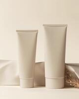 Two hand cream tubes on a beige paper background photo