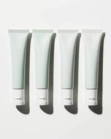 Four cream tubes positioned on a white surface photo