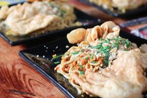 Gacoan noodles are a popular food in Indonesia. Made from noodles served with spicy spices and fried dumplings. photo