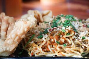 Gacoan noodles are a popular food in Indonesia. Made from noodles served with spicy spices and fried dumplings. photo
