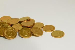 Chocolate coins. Brown coin money background on brown background. Coins are stacked on top of each other in different positions. Bunch of coins. photo