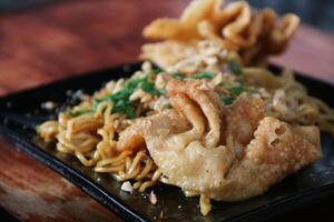 Gacoan noodles are a popular food in Indonesia. Made from noodles served with spicy spices and fried dumplings. photo