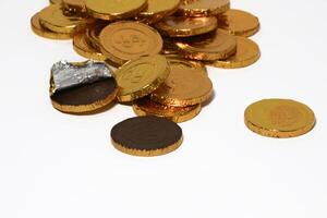 Chocolate coins. Brown coin money background on brown background. Coins are stacked on top of each other in different positions. Bunch of coins. photo