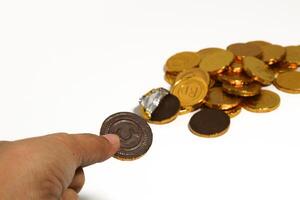 Chocolate coins. Brown coin money background on brown background. Coins are stacked on top of each other in different positions. Bunch of coins. photo