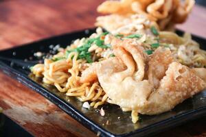 Gacoan noodles are a popular food in Indonesia. Made from noodles served with spicy spices and fried dumplings. photo