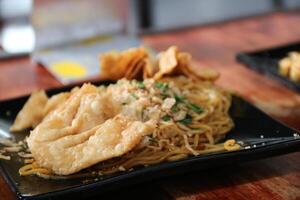 Gacoan noodles are a popular food in Indonesia. Made from noodles served with spicy spices and fried dumplings. photo