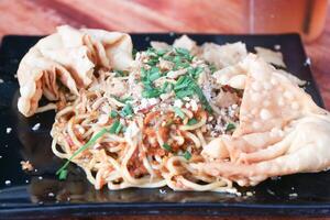 Gacoan noodles are a popular food in Indonesia. Made from noodles served with spicy spices and fried dumplings. photo