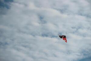 Colored paper kite like rainbow on blue sky background. Kites are flown along the beach. Beautiful colors in the air photo