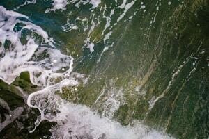 a foam and splash of green sea water photo
