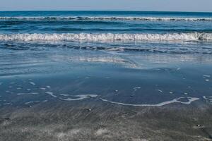 clear blue sea washes the shore photo