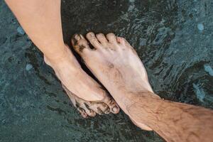 the bare feet of man and woman on the beach photo