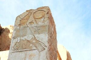 Part of the ancient egyptian temple. Drawings of Horus and snake on the wall in Luxor, Egypt. photo