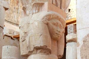 Part of the damaged column with face at ancient egyptian temple in Luxor, Egypt. photo