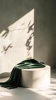 Sunlit shadow with green velvet on round pedestal, minimalist concept photo