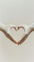 Hands in white gloves forming heart shape photo