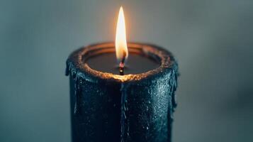 Black candle with flame in dim light, calming and serene atmosphere concept photo