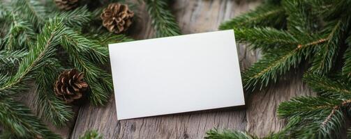 Christmas blank card surrounded by pine branches and cones on wooden surface, winter holiday concept photo