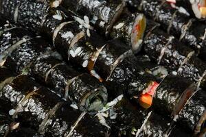 a pile of sushi rolls with different toppings photo