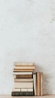Stack of neutral toned books against minimalistic backdrop for cozy reading atmosphere. photo