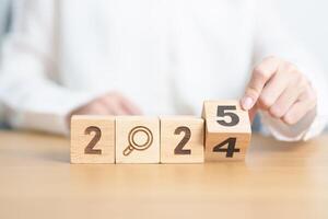 2024 year change to 2025 year block with magnifying glass icon. SEO, Search Engine Optimization, hiring , Advertising, Idea, Strategy, marketing, Keyword, Content and New Year start concepts photo