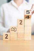 2024 year change to 2025 year block with jigsaw puzzle icon. Business Process, Team, teamwork, Goal, mission, Resolution, strategy, plan, Action, partnership, and New Year start photo