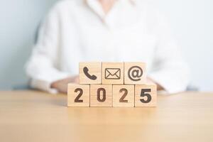 Happy New Year 2025 block for Contact Us concepts. Wood block of Email, call Phone and Website Address sign. For Customer support hotline, business Marketing, Corporate, communication and Advertising photo