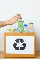 Volunteer keep plastic bottle into paper box at home or office. Hand Sorting Recycle garbage. Ecology, Environmental, pollution, Dispose recycling, waste management and trash Separation concept photo