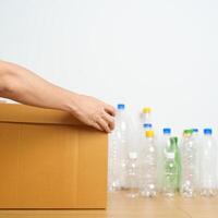 Volunteer keep plastic bottle into paper box at home or office. Hand Sorting Recycle garbage. Ecology, Environmental, pollution, Dispose recycling, waste management and trash Separation concept photo