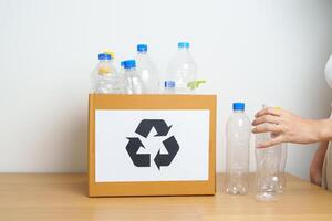 Volunteer keep plastic bottle into paper box at home or office. Hand Sorting Recycle garbage. Ecology, Environmental, pollution, Dispose recycling, waste management and trash Separation concept photo
