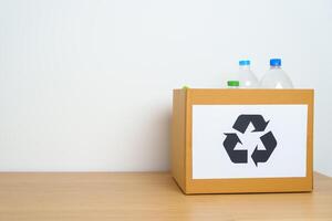 Plastic bottle in paper box at home or office. Recycle garbage Sorting. Plastic Free, Ecology, Environmental, pollution, Dispose recycling, waste management and trash Separation concept photo