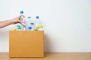 Volunteer keep plastic bottle into paper box at home or office. Hand Sorting Recycle garbage. Ecology, Environmental, pollution, Dispose recycling, waste management and trash Separation concept photo