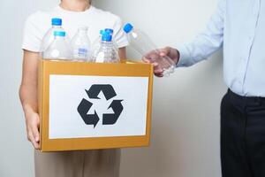 Volunteer keep plastic bottle into paper box at home or office. Hand Sorting Recycle garbage. Ecology, Environmental, pollution, Dispose recycling, waste management and trash Separation concept photo