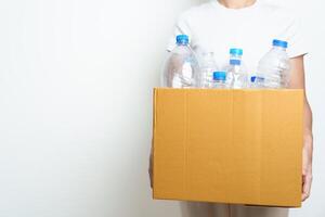 Volunteer keep plastic bottle into paper box at home or office. Hand Sorting Recycle garbage. Ecology, Environmental, pollution, Dispose recycling, waste management and trash Separation concept photo