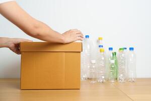 Volunteer keep plastic bottle into paper box at home or office. Hand Sorting Recycle garbage. Ecology, Environmental, pollution, Dispose recycling, waste management and trash Separation concept photo