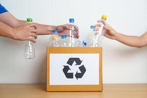 Volunteer keep plastic bottle into paper box at home or office. Hand Sorting Recycle garbage. Ecology, Environmental, pollution, Dispose recycling, waste management and trash Separation concept photo