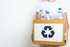 Volunteer keep plastic bottle into paper box at home or office. Hand Sorting Recycle garbage. Ecology, Environmental, pollution, Dispose recycling, waste management and trash Separation concept photo